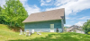 Blue exterior of side of home with sitting area outside