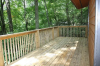 Wood deck with view of dense trees.