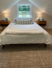 bedroom with vaulted ceilings and bed under a window