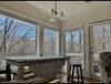 Farmhouse table with barstools and view of woods