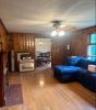 Living Room furnished with a blue couch and wood paneling