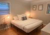 Furnished bedroom with windows on two walls