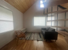 Sitting area with grey couch and short bookcase
